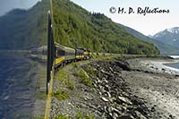 Alaska Railroad train rides the rim of Turnagain Arm of the Cook Inlet, AK