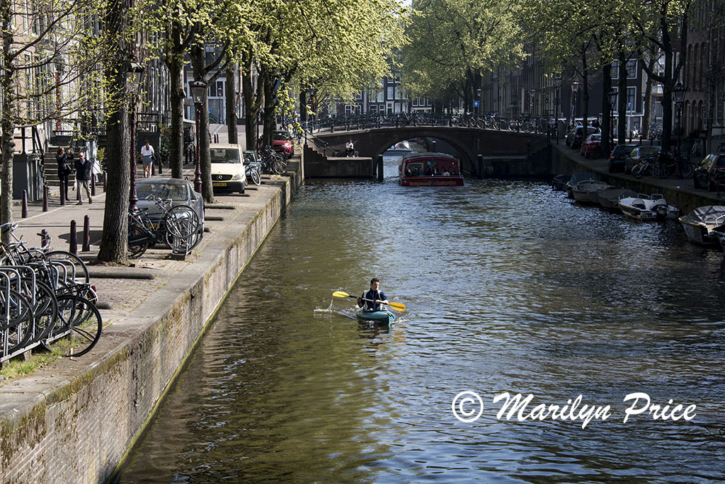 Kayaker paddles along a canal, the Liedesgracht, Amsterdam, Netherlands