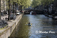 Kayaker paddles along a canal, the Liedesgracht, Amsterdam, Netherlands