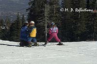 A father helps his young children at the Sandia Peak Ski Area, NM