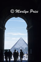 Glass pyramid entrance to the Louvre as seen through an arch, Paris, France