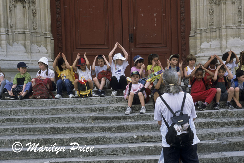 Schoolchildren sing a song on the steps of the Chapel at Chateau du Vincennes, Paris, France