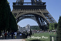 People picnic and walk under the base of the Eiffel Tower, Paris, France