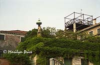 Statue atop a wall around a private garden, Venice, Italy