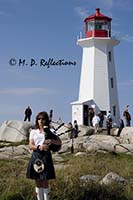 A piper entertains at the Light at Peggy's Point, Peggy's Cove, Nova Scotia