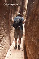 Carl 'pushes' the walls of the Slot canyon, Joint Trail, Canyonlands National Park, UT