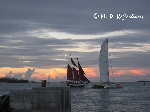 Sailboat with red sails and a catamaran, Sunset from Mallory Square, Key West, FL